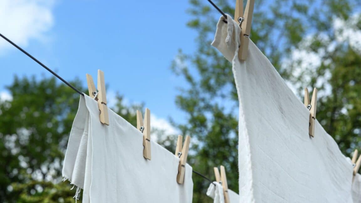 White towels hanging to dry with clothespins on a line outdoors